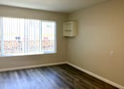 Thumbnail 16 of 20 - Bedroom with a large window and wooden floors
