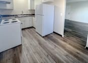 Thumbnail 29 of 34 - Monterey Manor Vacant Apartment dining and kitchen with white cabinets and a stove and vinyl plank floor