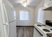 Thumbnail 28 of 34 - Monterey Manor Vacant Apartment Kitchen with vinyl plank, fridge, stove and dining room