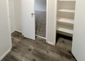 Thumbnail 30 of 34 - Monterey Manor Vacant Apartment hallway with two storage closets and vinyl plank floor