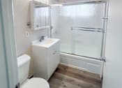 Thumbnail 34 of 34 - Monterey Manor Vacant Apartment Bathroom with vinyl plank floor, tub/shower, sink, and toilet