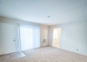 Thumbnail 16 of 34 - Monterey Manor vacant apartment living rooom with carpet and sliding glass door to patio