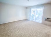 Thumbnail 13 of 34 - Monterey Manor vacant apartment living room with carpet and glass sliding door