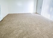 Thumbnail 15 of 34 - Monterey Manor vacant apartment living rooom with carpet and sliding glass door to patio
