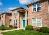 Thumbnail 10 of 14 - Brick apartment building with a green door at Maple Tree Apartments in LaPorte, IN