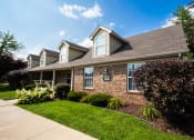 Thumbnail 1 of 14 - Clubhouse with a green lawn and bushes at Maple Tree Apartments in LaPorte, IN