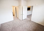 Thumbnail 7 of 34 - A carpeted room with a white door and a white wall.