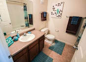 Thumbnail 8 of 19 - A bathroom with a toilet, sink, and mirror.