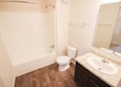 Thumbnail 13 of 34 - A white toilet sits next to a sink in a bathroom.