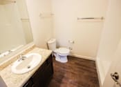 Thumbnail 10 of 34 - A white toilet sits in a bathroom next to a sink.