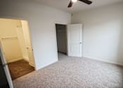 Thumbnail 9 of 34 - A room with a ceiling fan and two doors.