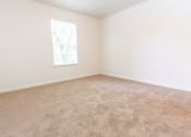 Thumbnail 11 of 14 - An empty bedroom with white walls, a window, and carpet at Maple Tree Apartments in LaPorte, IN