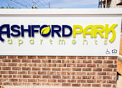 Thumbnail 2 of 34 - A sign for Ashford Park Apartments is displayed on a brick wall.