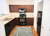 Thumbnail 4 of 34 - A kitchen with a black refrigerator and black oven.