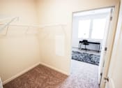 Thumbnail 24 of 34 - A room with a carpeted floor and a white door leading to another room.