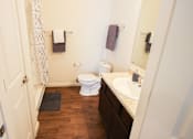 Thumbnail 28 of 34 - A white toilet sits in a bathroom next to a sink.