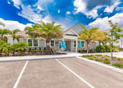 Thumbnail 1 of 57 - Swiftwater apartments clubhouse building with a parking lot and palm trees in front of it