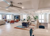 Thumbnail 9 of 57 - a living room with tables and chairs and a ceiling fan at Swiftwater apartments in Port Charlotte, FL