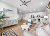 Thumbnail 1 of 83 - A living room with a white couch and a painting on the wall.