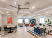 Thumbnail 11 of 57 - a living room with tables and chairs and a ceiling fan at Swiftwater apartments in Port Charlotte, FL