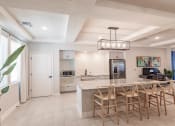 Thumbnail 13 of 57 - Community kitchen at Swiftwater apartments in port charlotte with a marble counter top island and chairs