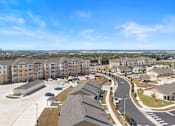 Thumbnail 47 of 58 - A view of a residential area with apartment buildings and cars parked in the parking lot.