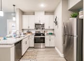 Thumbnail 36 of 94 - an open kitchen with stainless steel appliances and white cabinets