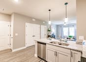 Thumbnail 37 of 94 - an open kitchen and living room with white cabinets and a counter top