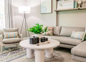 Thumbnail 43 of 94 - a living room with couches and a coffee table with a plant