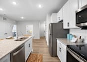 Thumbnail 5 of 83 - A modern kitchen with stainless steel appliances and white cabinets.