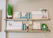 Thumbnail 44 of 94 - a wall shelf with books and pictures and plants on it