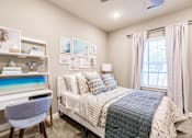 Thumbnail 49 of 94 - a bedroom with a bed and a desk and a window at Vantage Luxury Apartments in Cape Coral, Fl