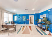 Thumbnail 4 of 57 - A living room with blue walls and a table and chairs at Swiftwater apartments in Port Charlotte, FL
