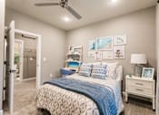 Thumbnail 50 of 94 - a bedroom with a bed and a ceiling fan