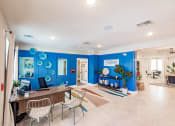 Thumbnail 5 of 57 - living room area at swiftwater apartments clubhouse with blue walls and a table