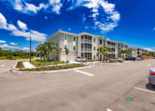 Thumbnail 3 of 57 - an empty parking lot in front of swiftwater apartment building with palm trees