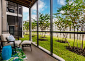 Thumbnail 46 of 94 - a screened in balcony with a chair at Vantage Luxury Apartments in  Cape Coral, FL