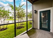 Thumbnail 47 of 94 - a patio with a green door and a view of a lake and trees