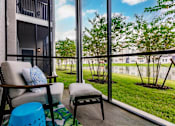 Thumbnail 45 of 94 - a balcony with a couch and a chair and a view of the grass