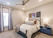 Thumbnail 28 of 57 - a bedroom with a bed and a ceiling fan at  a living room with tables and chairs and a ceiling fan at Swiftwater apartments in Port Charlotte, FL