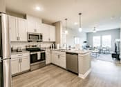 Thumbnail 55 of 94 - a kitchen with stainless steel appliances and white cabinets at Vantage Luxury Apartments in  Cape Coral, FL