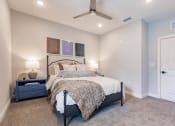 Thumbnail 27 of 57 - a bedroom with a bed and a ceiling fan at  a living room with tables and chairs and a ceiling fan at Swiftwater apartments in Port Charlotte, FL