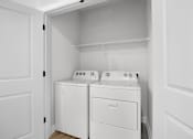 Thumbnail 14 of 83 - A white laundry room with a washer and dryer.