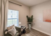 Thumbnail 38 of 57 - small room with a chair, end table and a plant at  a living room with tables and chairs and a ceiling fan at Swiftwater apartments in Port Charlotte, FL