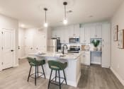 Thumbnail 20 of 57 - an open kitchen with a large island with two stools at swiftwater luxury apartments in port charlotte, fl