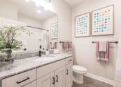 Thumbnail 34 of 57 - a bathroom with a sink and a toilet at  a living room with tables and chairs and a ceiling fan at Swiftwater apartments in Port Charlotte, FL