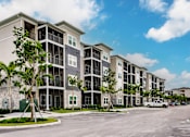 Thumbnail 17 of 94 - Vantage apartment building with trees and a parking lot