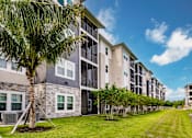 Thumbnail 14 of 94 - an apartment building with palm trees in front of it