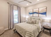 Thumbnail 32 of 57 - a bedroom with a bed and a ceiling fan at  a living room with tables and chairs and a ceiling fan at Swiftwater apartments in Port Charlotte, FL