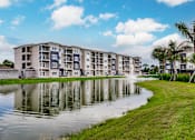 Thumbnail 16 of 94 - Vantage apartment building overlooking a pond with a fountain